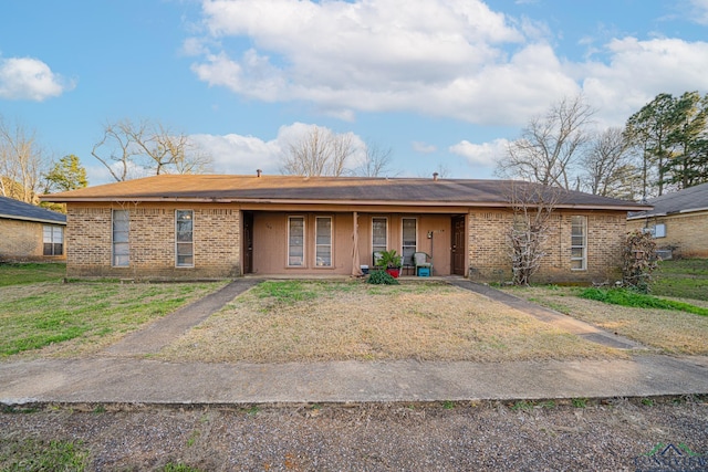 single story home with a porch, a front lawn, and brick siding