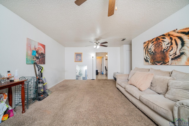 carpeted living area with a textured ceiling, visible vents, and a ceiling fan