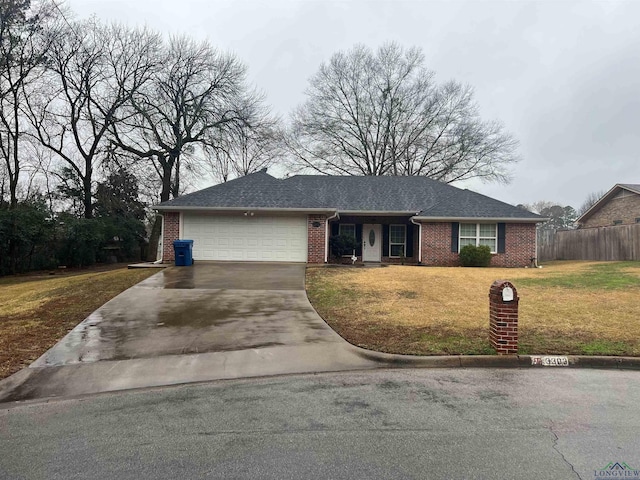 single story home with brick siding, an attached garage, a front yard, fence, and driveway