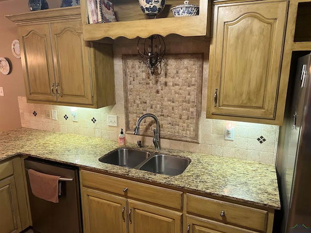 kitchen featuring backsplash, light stone counters, stainless steel appliances, and a sink