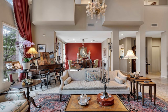 living room with a towering ceiling and a notable chandelier