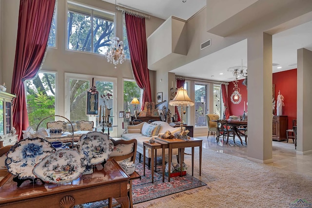 tiled living room with a towering ceiling, an inviting chandelier, and a wealth of natural light