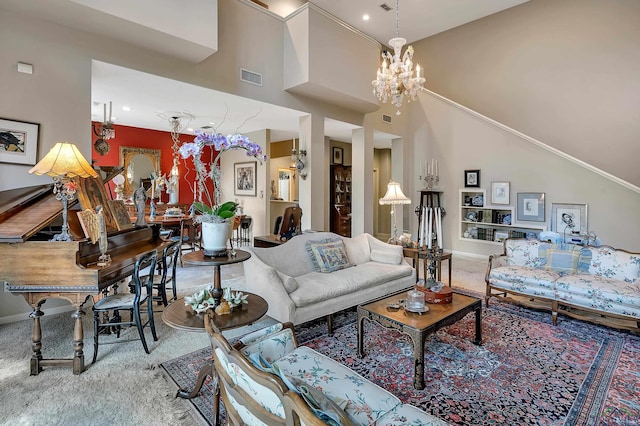 carpeted living room featuring a towering ceiling and a notable chandelier