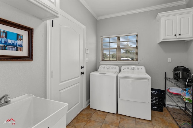 laundry room with a sink, ornamental molding, cabinet space, and washer and clothes dryer