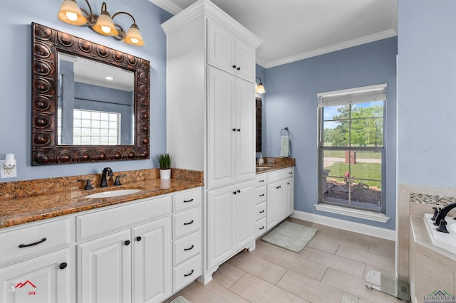 full bath featuring two vanities, baseboards, ornamental molding, a relaxing tiled tub, and a sink