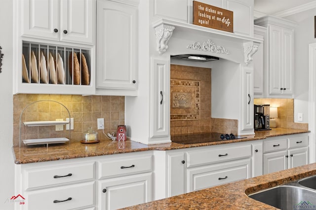 kitchen with backsplash, white cabinets, dark stone counters, and black electric stovetop
