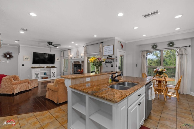 kitchen with an island with sink, visible vents, dishwasher, and a sink
