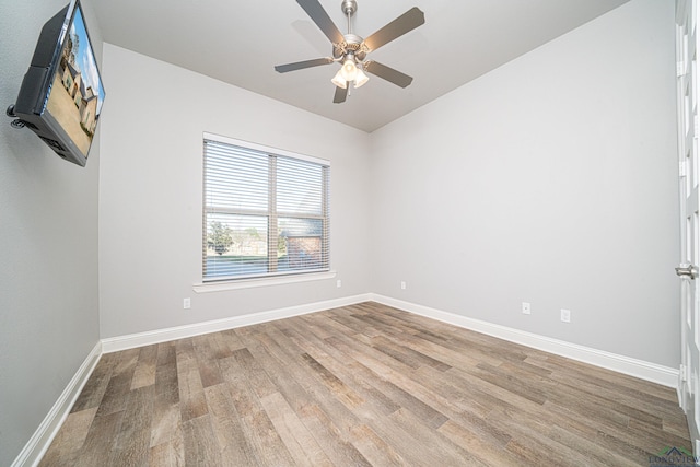 empty room featuring wood finished floors, a ceiling fan, and baseboards