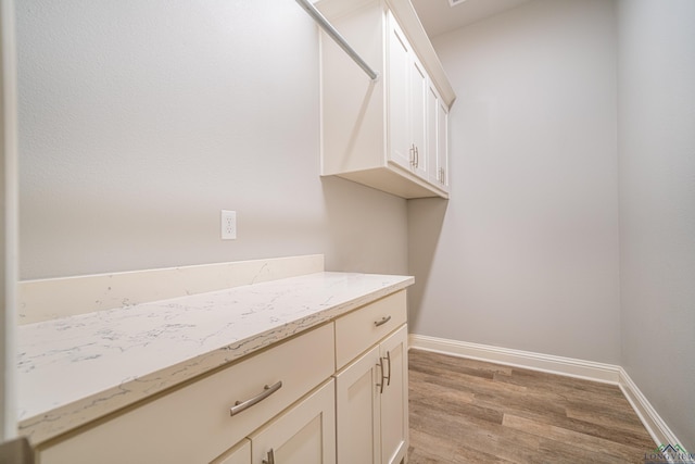 washroom with light wood-type flooring and baseboards