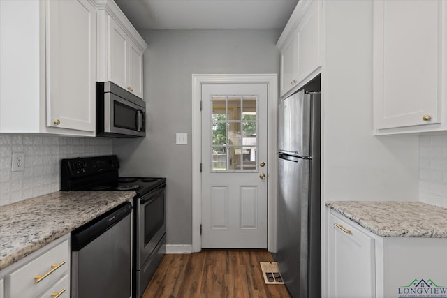 513 E Young, Longview, TX 75602 - kitchen with stainless steel appliances, white cabinetry, dark wood finished floors, and backsplash