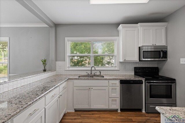 513 E Young, Longview, TX 75602 - kitchen with stainless steel appliances, a sink, tasteful backsplash, white cabinets, and dark wood-style floors