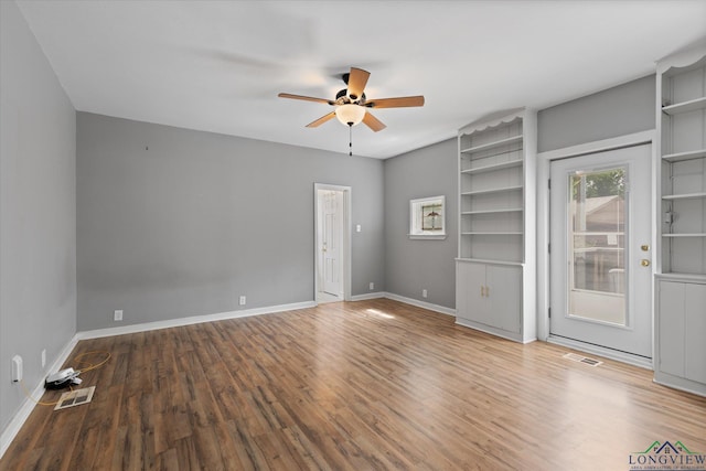 513 E Young, Longview, TX 75602 - empty room featuring ceiling fan, wood finished floors, baseboards, and built in features