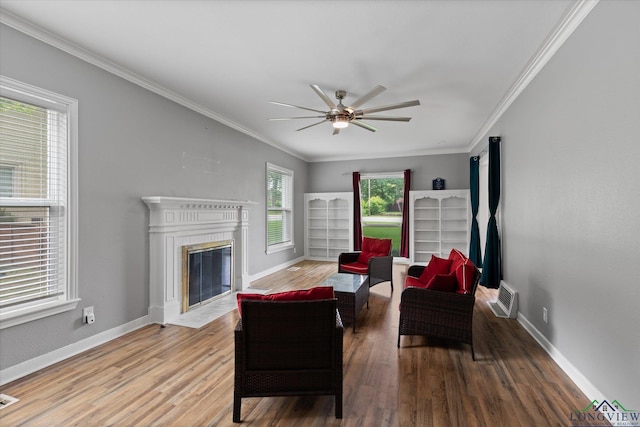 513 E Young, Longview, TX 75602 - living area with wood finished floors, a ceiling fan, baseboards, a fireplace with flush hearth, and ornamental molding