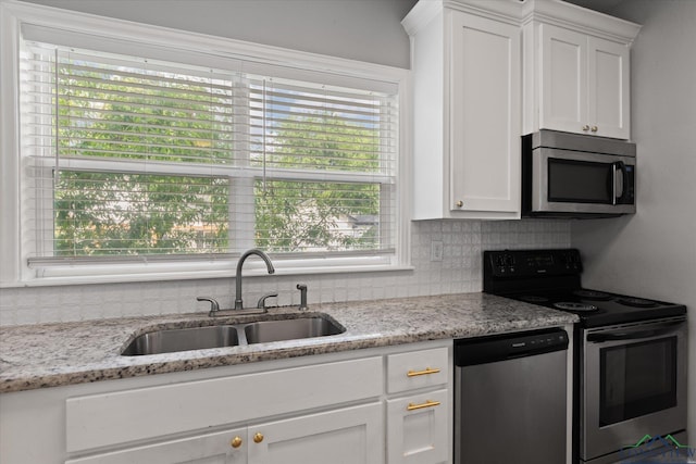 513 E Young, Longview, TX 75602 - kitchen with stainless steel appliances, a sink, tasteful backsplash, and white cabinetry