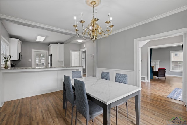 513 E Young, Longview, TX 75602 - dining space with a chandelier, wood finished floors, crown molding, and a wainscoted wall