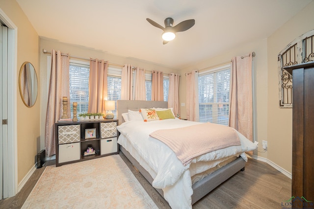 bedroom with a ceiling fan, baseboards, and wood finished floors