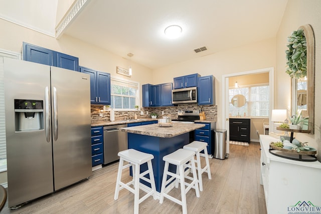 kitchen featuring blue cabinets, visible vents, appliances with stainless steel finishes, and decorative backsplash