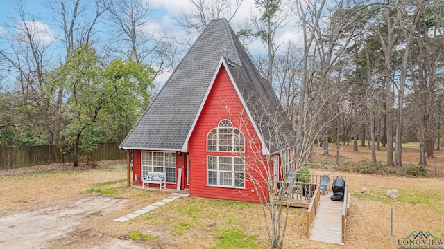 view of outdoor structure with driveway and fence