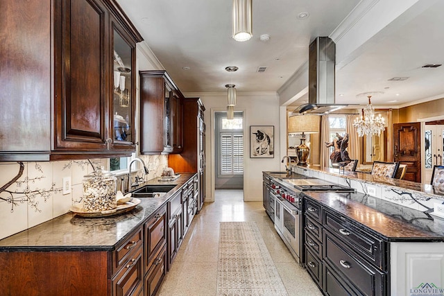 kitchen featuring range with two ovens, a sink, hanging light fixtures, island exhaust hood, and glass insert cabinets