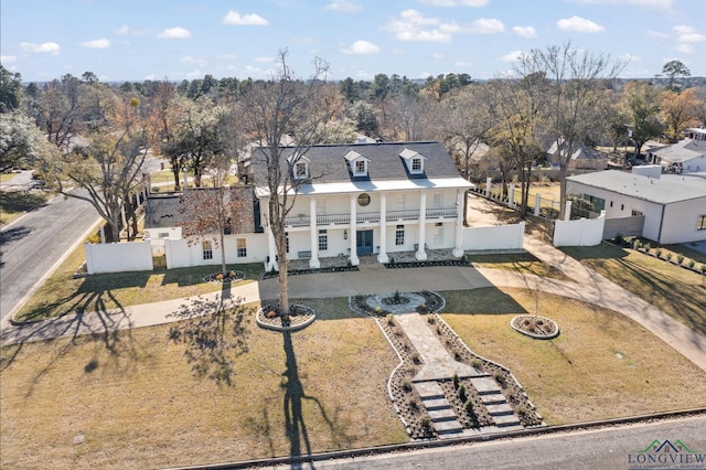 view of front of property with driveway, a fenced front yard, and a residential view