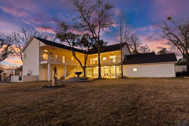 rear view of property with a patio, stairway, a lawn, and a balcony