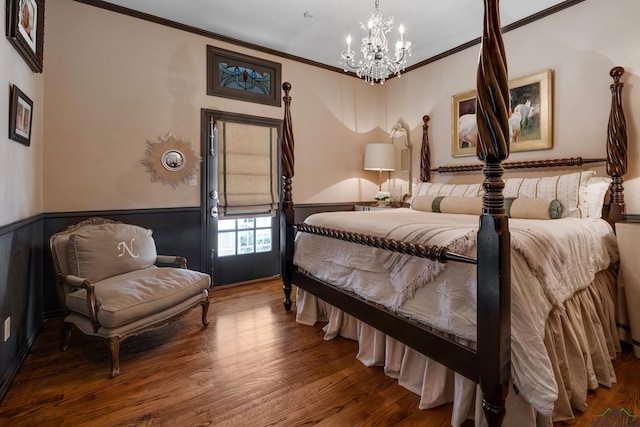 bedroom with a wainscoted wall, a notable chandelier, wood finished floors, and crown molding