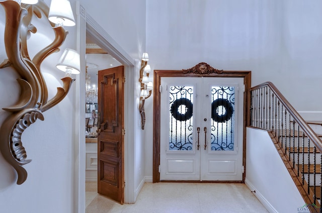 entrance foyer featuring french doors, stairway, and baseboards