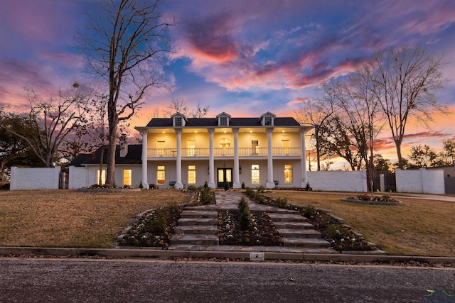 view of front of house with a balcony and fence