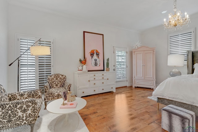 bedroom featuring a chandelier, light wood-type flooring, and crown molding