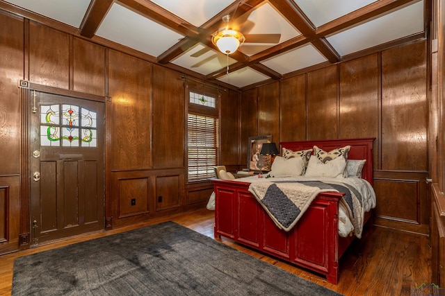 bedroom featuring wood walls, beam ceiling, coffered ceiling, and dark wood-style flooring