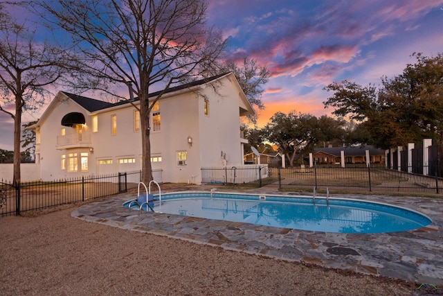 pool at dusk with fence and a fenced in pool