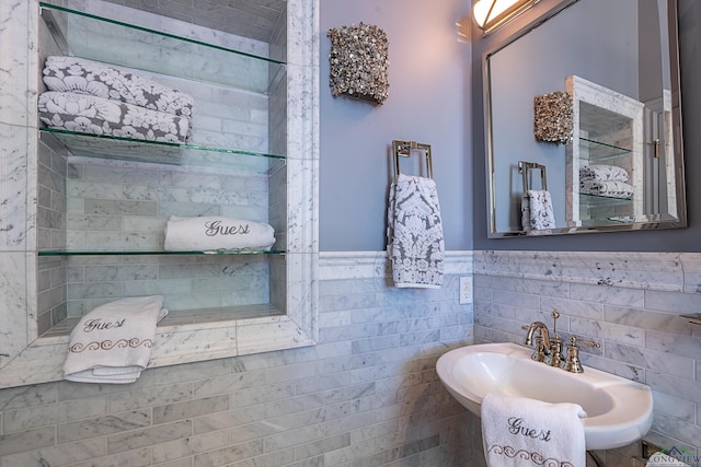 bathroom featuring tile walls, a sink, and wainscoting