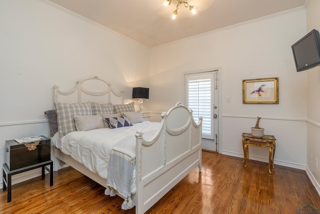 bedroom featuring ornamental molding, wood finished floors, and baseboards