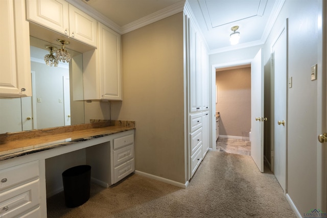 unfurnished office with light carpet, built in desk, and ornamental molding