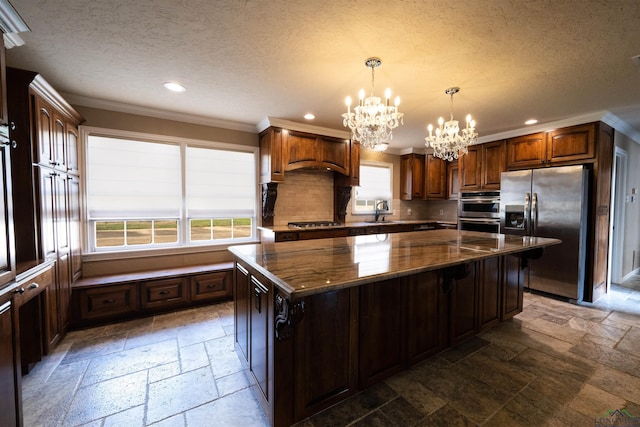 kitchen with stainless steel appliances, an inviting chandelier, tasteful backsplash, dark stone counters, and a kitchen island