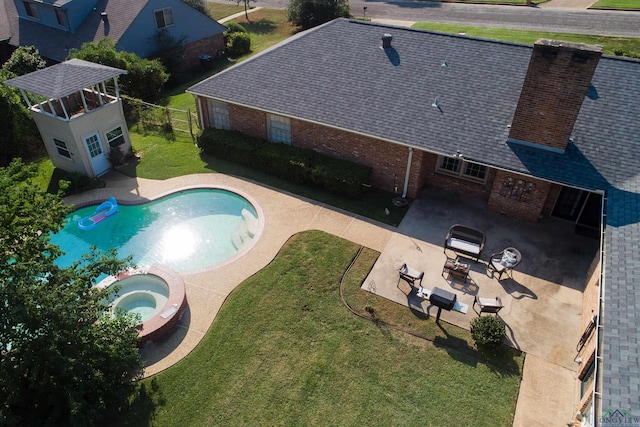 view of swimming pool featuring a patio area, an in ground hot tub, and a yard