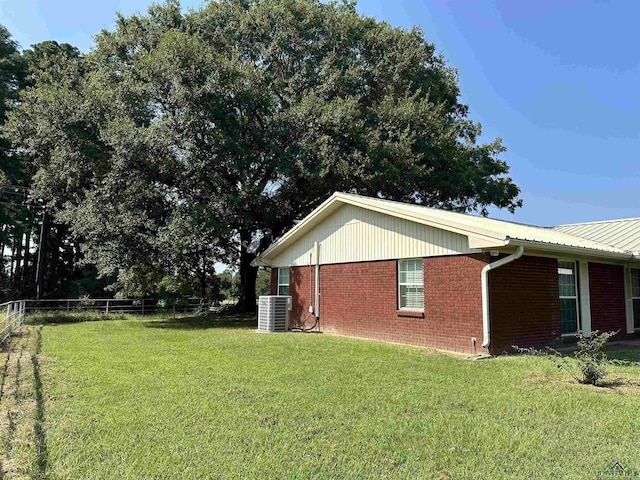 view of property exterior with cooling unit and a yard