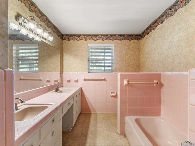 bathroom featuring vanity, tile walls, and a tub