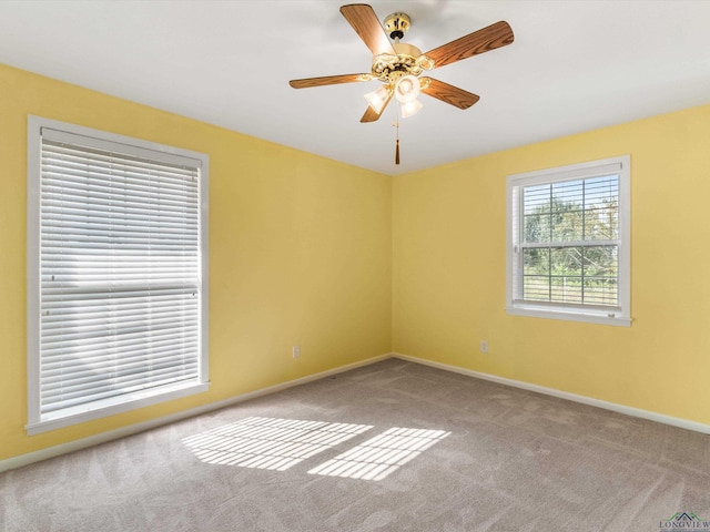 carpeted spare room featuring ceiling fan