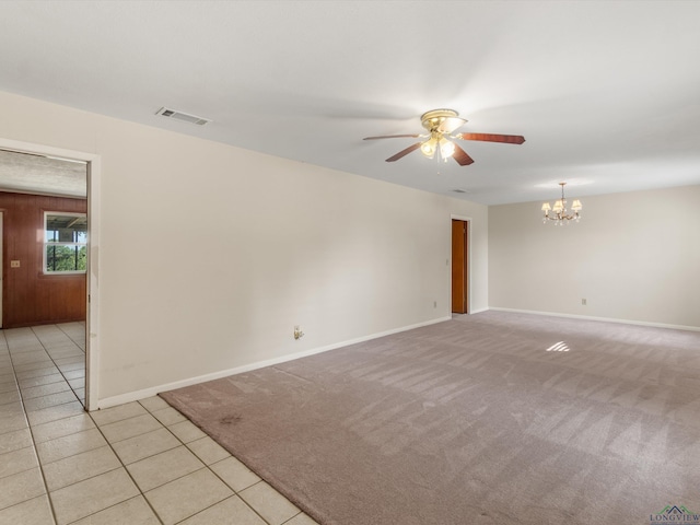 unfurnished room with ceiling fan with notable chandelier and light tile patterned floors