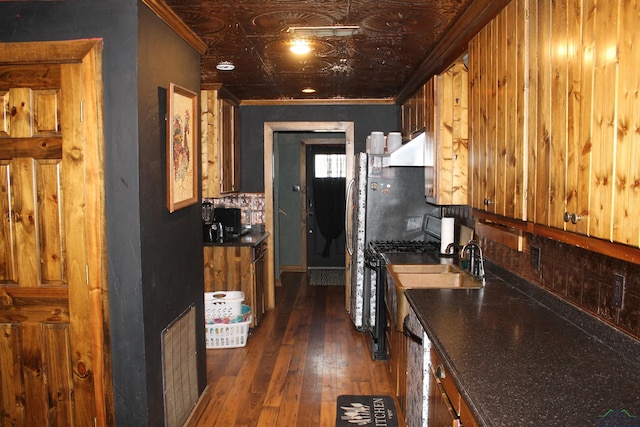 kitchen with black gas range, dishwashing machine, dark hardwood / wood-style flooring, and ornamental molding