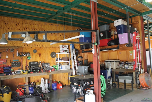 garage featuring a workshop area and wooden walls