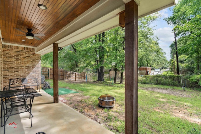 view of yard featuring a fire pit, ceiling fan, and a patio area