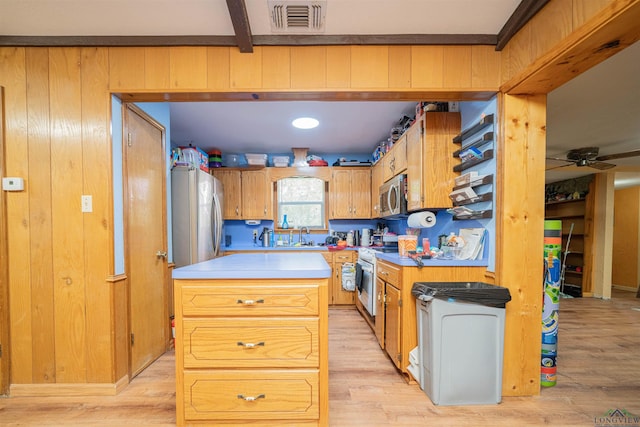 8123 Cherokee Trce, Gilmer, TX 75644 - kitchen with appliances with stainless steel finishes, light wood-style floors, ceiling fan, light countertops, and a kitchen island