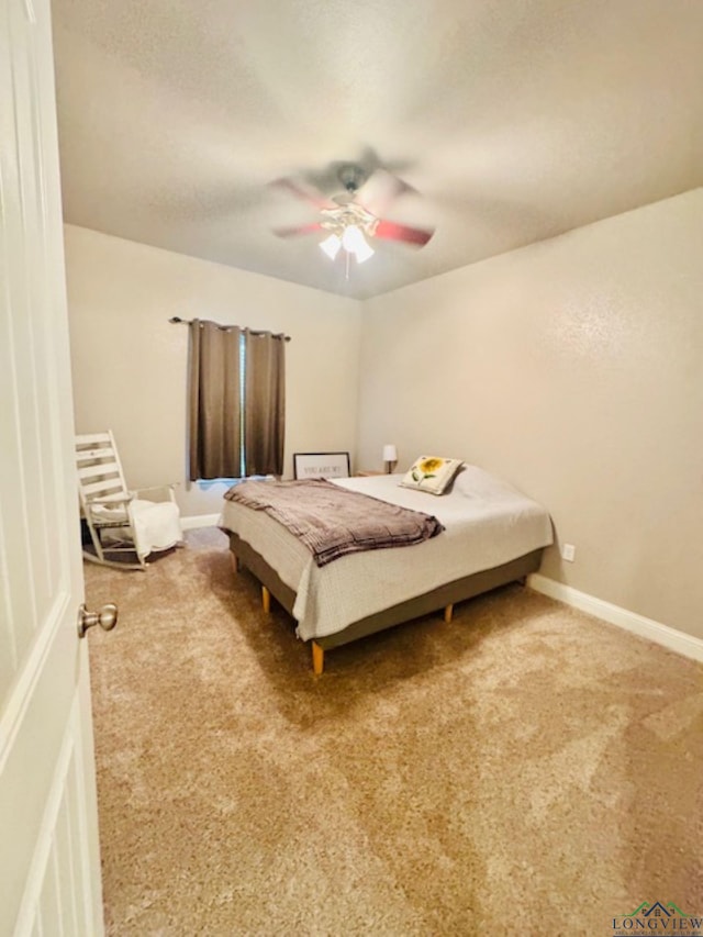 carpeted bedroom with a ceiling fan and baseboards