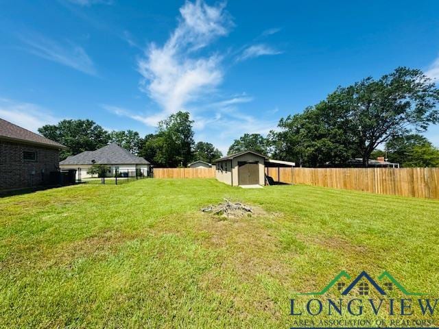 view of yard with an outbuilding, a fenced backyard, and a shed