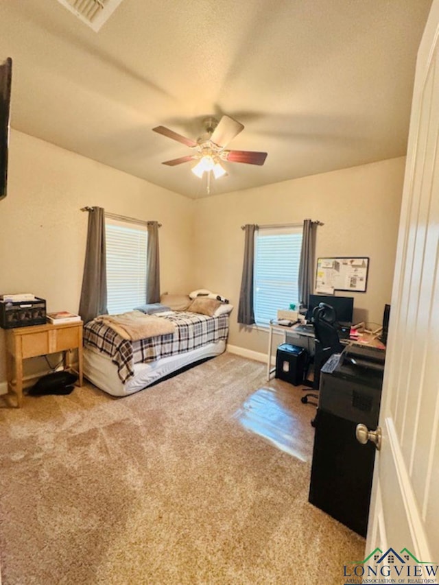 bedroom with baseboards, carpet flooring, visible vents, and ceiling fan