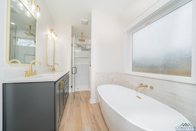 bathroom with vanity, plus walk in shower, and tile walls