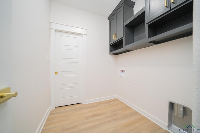 washroom with washer hookup, hardwood / wood-style flooring, and cabinets