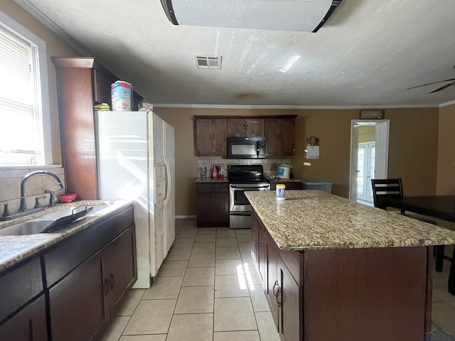 kitchen with stainless steel electric range, white refrigerator with ice dispenser, a sink, visible vents, and black microwave